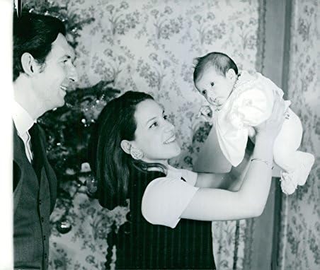 Foto vintage do príncipe Michael da Grécia e sua esposa carregando seu bebê.